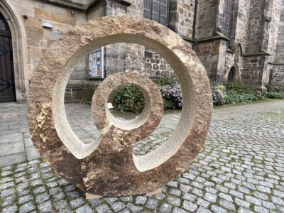 Ein kunstvoll ausgearbeitetes Sandsteinobjekt vor der Stiftskirche Obernkirchen